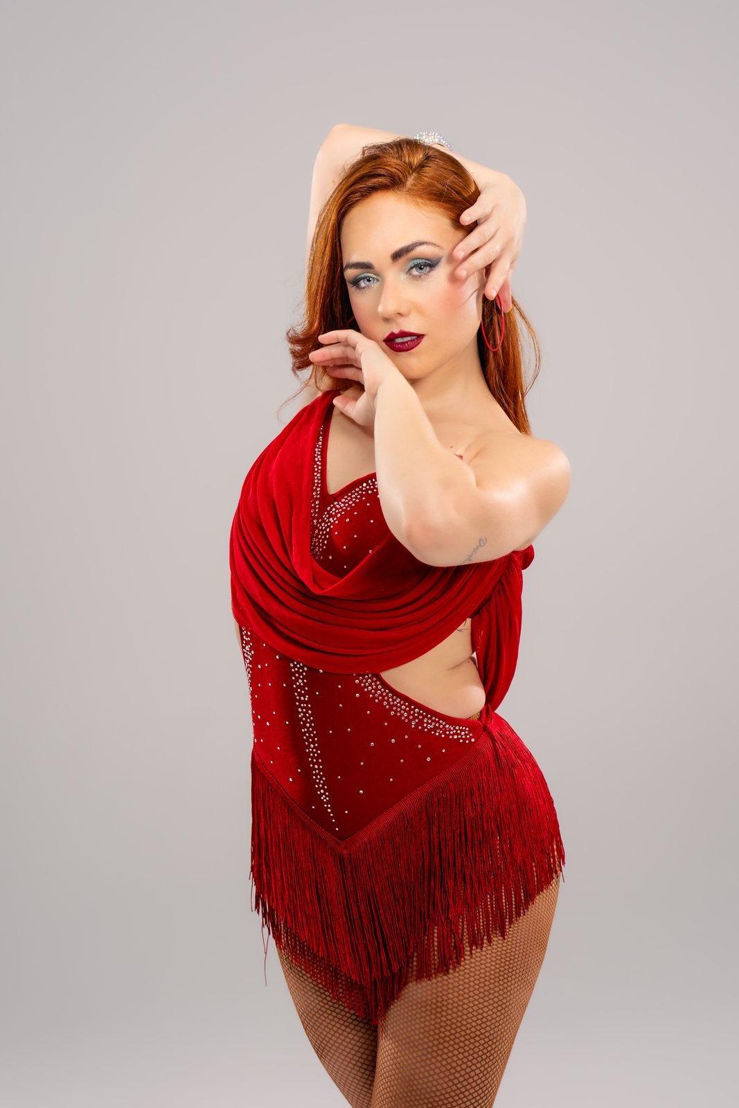 Irene Palomares mirando a camara con vestido rojo de flecos